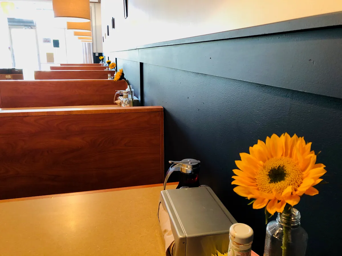 A booth with a sunflower on the table